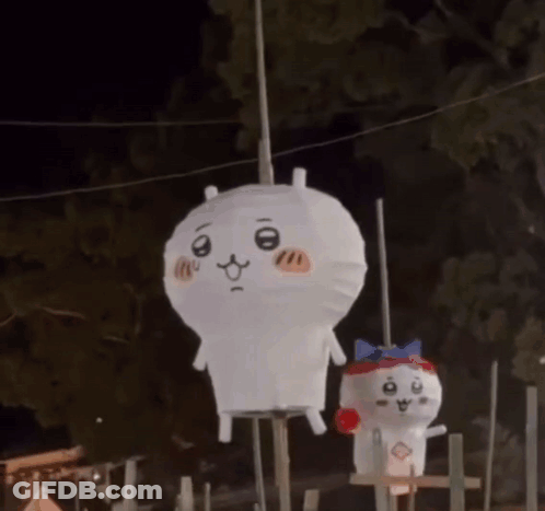 Two Stuffed Animals Are Hanging From A Rope In The Dark . GIF