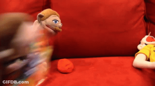 Two Stuffed Animals Are Sitting On A Red Couch And One Has Blue Eyes GIF