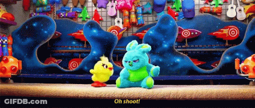 Two Stuffed Animals Are Standing In Front Of A Display Of Rockets And Balloons And One Of Them Says Oh Shoot GIF