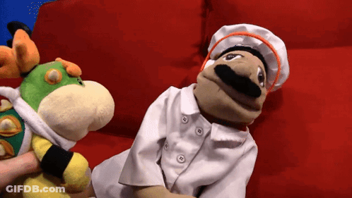 Two Stuffed Animals On Red Couch One In Chef Costume GIF