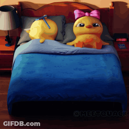 Two Stuffed Ducks On Bed With 7:00 Clock GIF