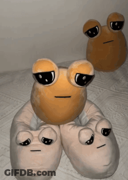 Two Stuffed Frogs Are Sitting On A Bed With Their Eyes Closed GIF