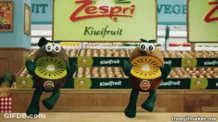 Two Stuffed Kiwi Fruits Are Dancing In Front Of A Zespri Sign GIF