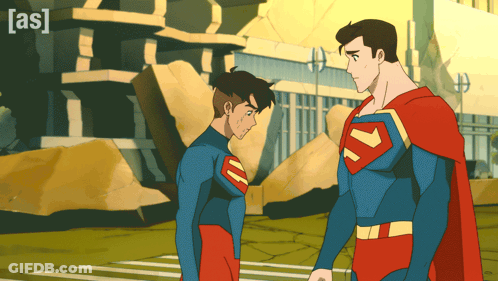 Two Superheroes Standing With Building Saying As GIF