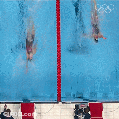 Two Swimmers Are Swimming In A Pool With The Olympic Rings On The Bottom GIF
