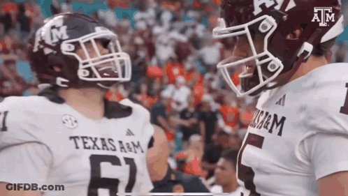 Two Texas A&M Football Players Talking On Field GIF