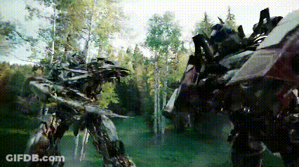 Two Transformers Are Fighting In A Forest With Trees In The Background GIF
