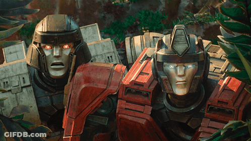Two Transformers Standing With Glowing Eyes GIF