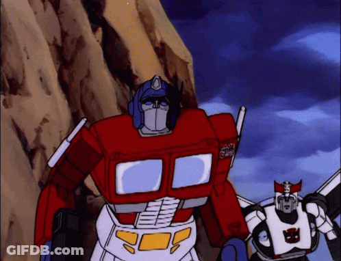 Two Transformers With Optimus Prime Text On Chest GIF