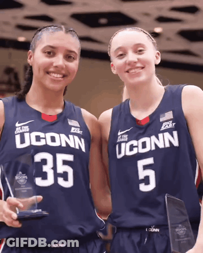 Two Uconn Basketball Players Are Holding Trophies GIF