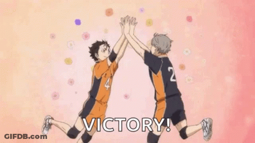 Two Volleyball Players Are Giving Each Other A High Five While Jumping In The Air . GIF