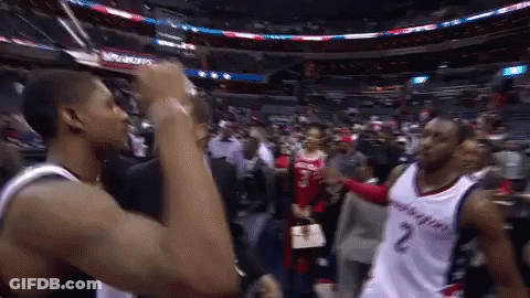 Two Washington Wizards Basketball Players Are Shaking Hands In A Stadium GIF