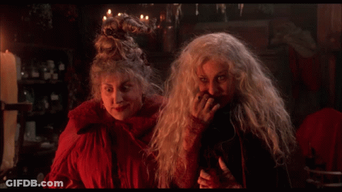 Two Witches Are Standing Next To Each Other And The Word Sorry Is On The Screen Behind Them GIF