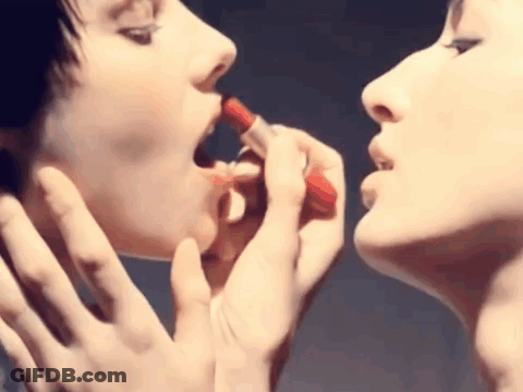 Two Women Applying Red Lipstick To Each Other GIF
