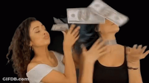 Two Women Are Blowing Money In The Air While One Of Them Has A Stack Of Money On Her Head . GIF