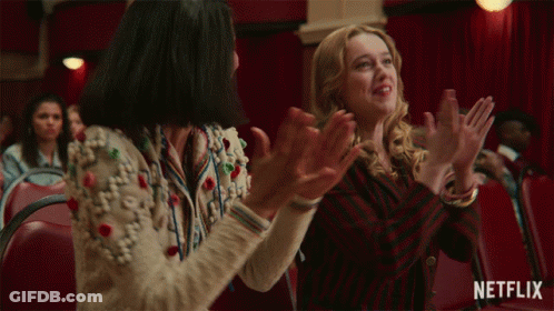 Two Women Are Clapping In A Theater With A Netflix Logo In The Corner GIF