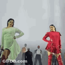 Two Women Are Dancing In Front Of A Crowd Of People . GIF