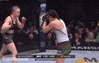 Two Women Are Fighting In A Boxing Ring With The UFC Logo In The Background GIF
