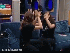 Two Women Are Fighting On A Couch With A Pizza Box In The Background That Says ' Roast Time ' GIF