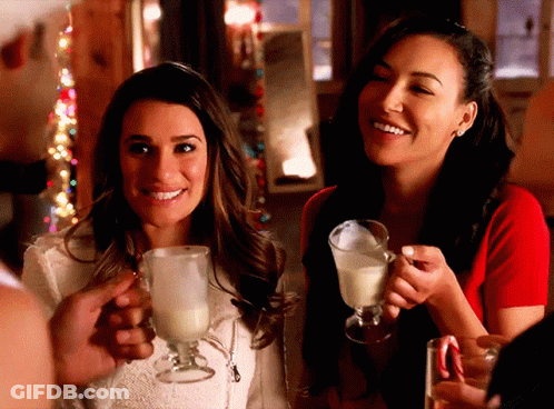 Two Women Are Holding Glasses Of Milk And Smiling At The Camera GIF