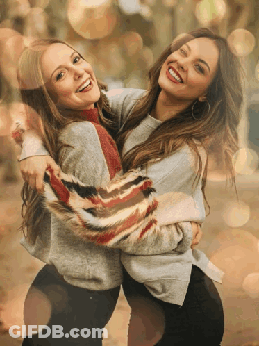 Two Women Are Hugging Each Other And Smiling For A Picture GIF