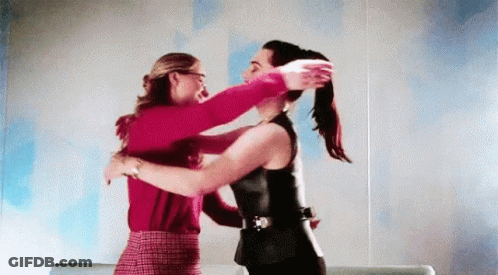 Two Women Are Hugging Each Other In A Room And One Of Them Is Holding The Other 'S Hair . GIF