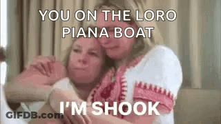 Two Women Are Hugging Each Other On A Bed And One Of Them Is Talking . GIF