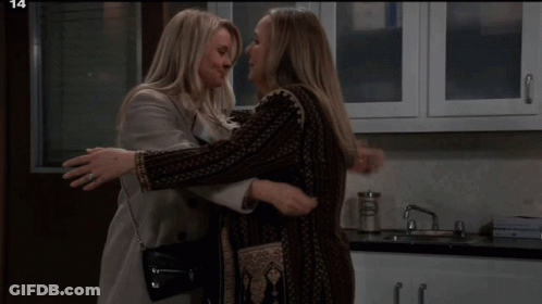 Two Women Are Hugging In A Kitchen With The Number 14 In The Corner GIF