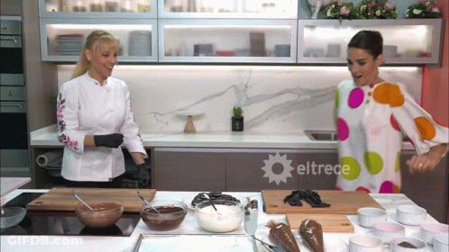 Two Women Are In A Kitchen With Eltrece Written On The Counter GIF