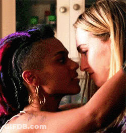 Two Women Are Kissing Each Other In A Kitchen . GIF