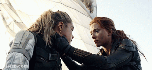 Two Women Are Looking At Each Other And One Is Holding The Other 'S Hand GIF