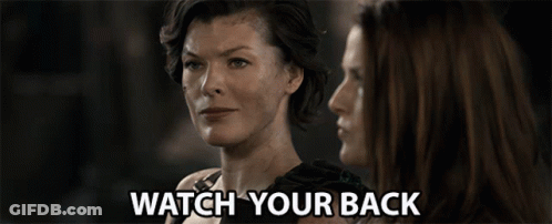Two Women Are Looking At Each Other And The Words Watch Your Back Are Visible GIF