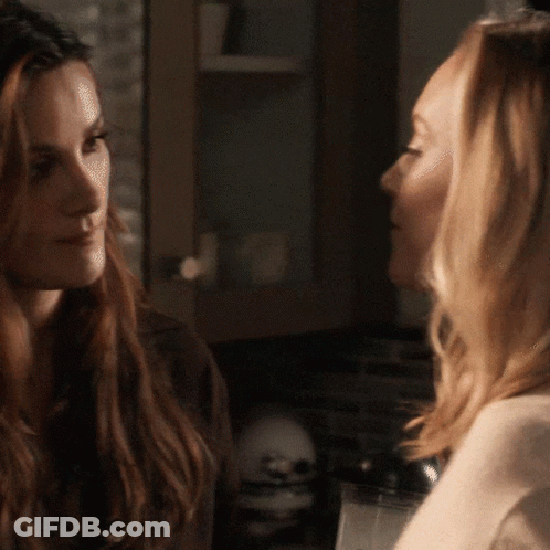 Two Women Are Looking At Each Other In A Kitchen GIF
