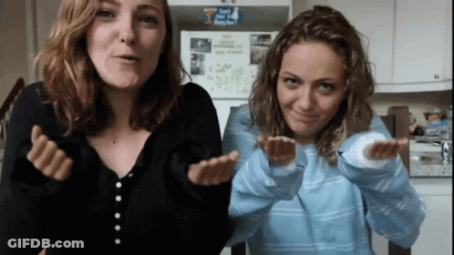 Two Women Are Making Funny Faces In Front Of A Refrigerator That Has A Sticker On It That Says " I Love You " GIF