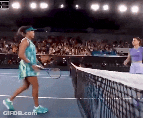 Two Women Are Playing Tennis On A Court And One Is Wearing A Blue Dress GIF