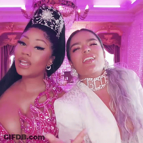 Two Women Are Posing For A Picture And One Has A Necklace That Says God On It GIF