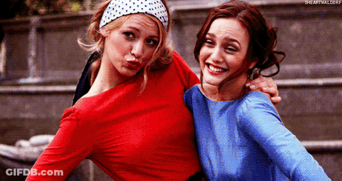 Two Women Are Posing For A Picture Together And One Is Wearing A Red Top And The Other Is Wearing A Blue Top . GIF