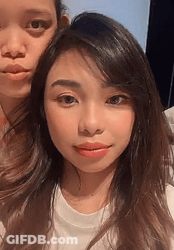 Two Women Are Posing For A Picture Together And One Of Them Is Wearing A White T-Shirt . GIF