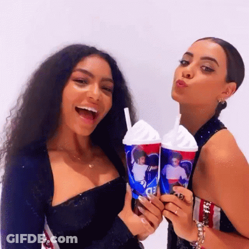Two Women Are Posing For A Picture While Holding A Cup That Says Pepsi GIF
