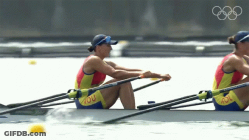 Two Women Are Rowing In A Boat With Rou On Their Pants GIF