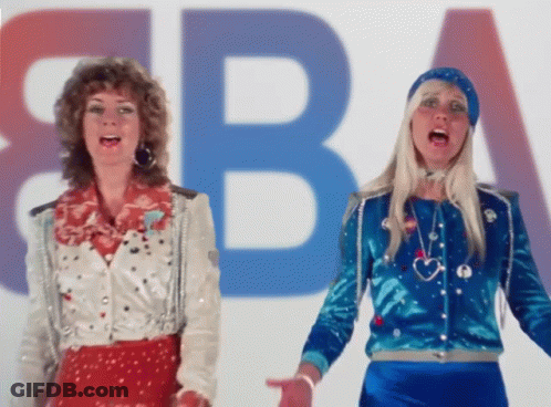Two Women Are Singing In Front Of A Large Letter B GIF