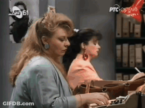 Two Women Are Sitting At A Desk With Ptc Satellite Written On The Bottom GIF