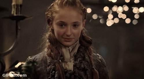 Two Women Are Sitting At A Table With A Cake In Front Of Them GIF