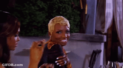 Two Women Are Sitting At A Table With A Glass Of Wine . GIF