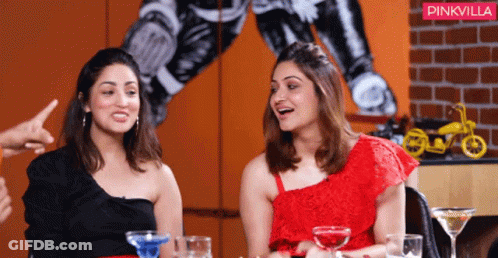 Two Women Are Sitting At A Table With Drinks And A Pinkvilla Logo Behind Them GIF