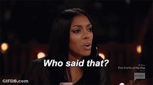 Two Women Are Sitting At A Table With Glasses Of Champagne And A Fire In The Background . GIF