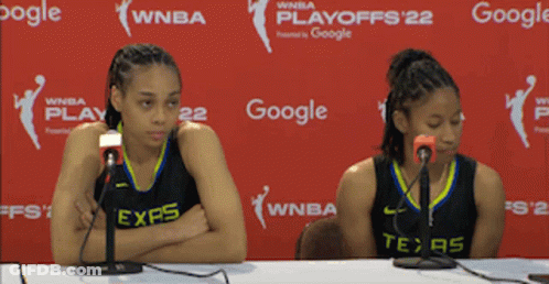 Two Women Are Sitting At A Table With Microphones In Front Of A Google Banner GIF