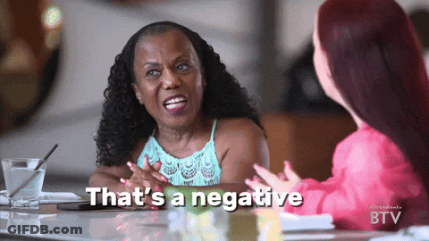 Two Women Are Sitting At A Table With The Words That 'S A Negative Written On The Screen GIF