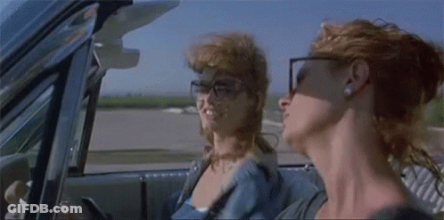 Two Women Are Sitting In A Car Looking Out The Window . GIF
