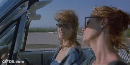 Two Women Are Sitting In A Car Looking Out The Window . GIF